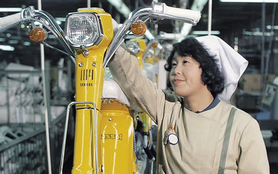 Ouvrière Yamaha contrôlant un Passol jaune sur la chaîne d'assemblage entièrement féminine de 1977