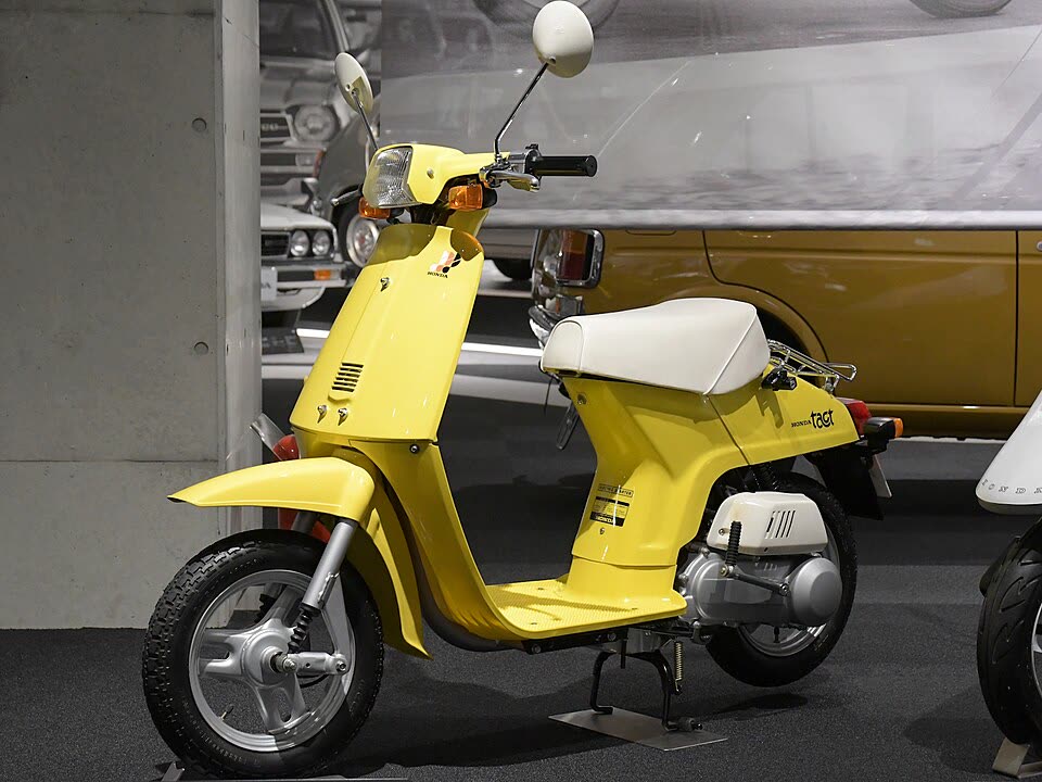 Honda Tact jaune de 1980, carrosserie enveloppante et plancher plat, exposé au musée Honda de Motegi