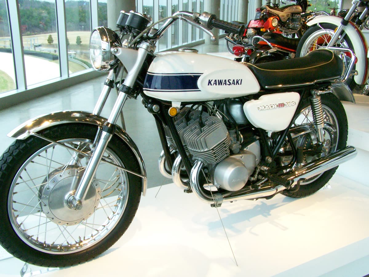 Kawasaki 500 Mach III blanche exposée dans un musée, moteur trois cylindres deux-temps bien visible